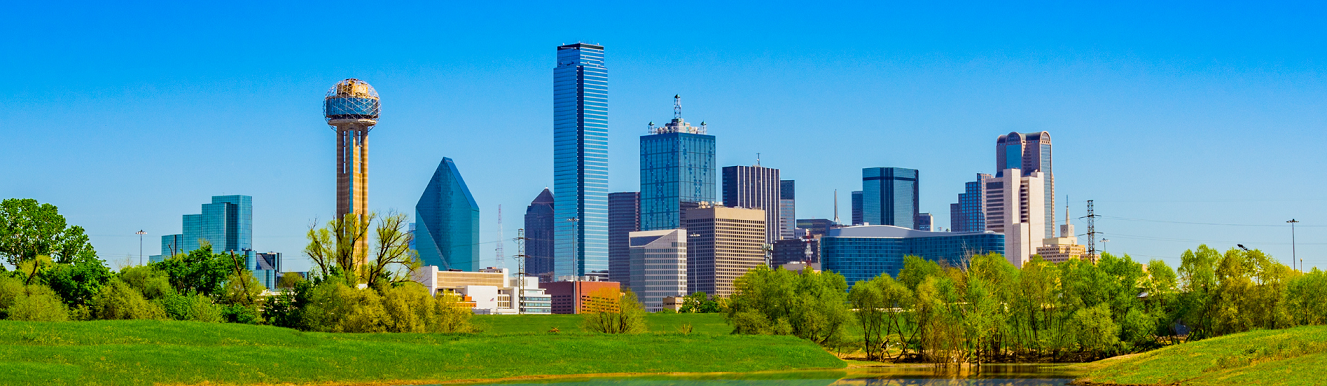 A park with trees and tall buildings in the background.