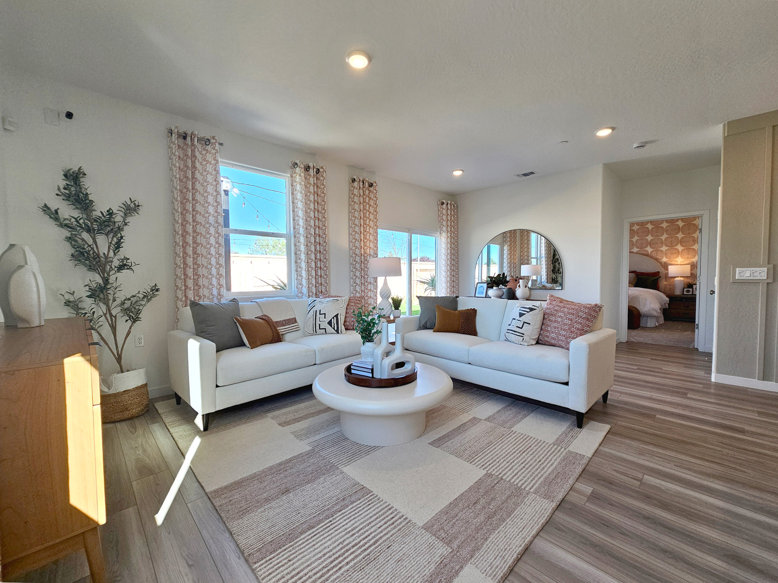A living room with a rug and a large window.