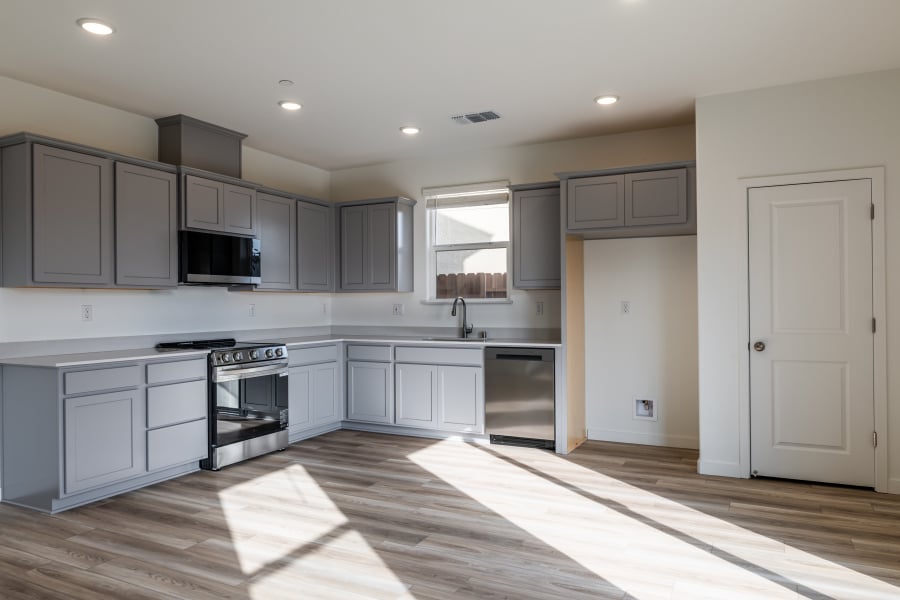 A kitchen with white cabinets.