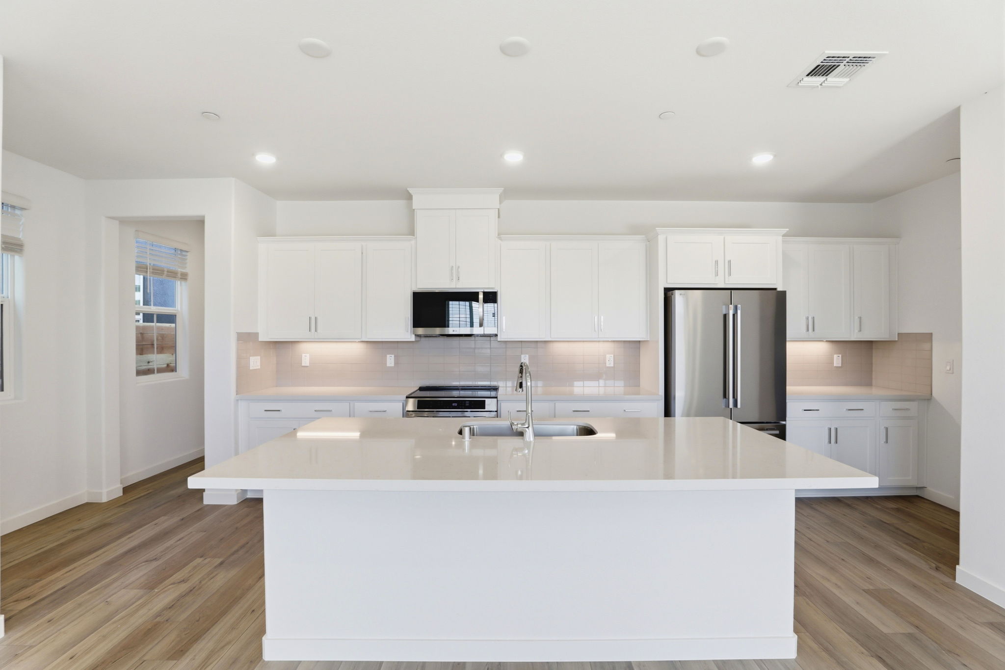 A kitchen with white cabinets.