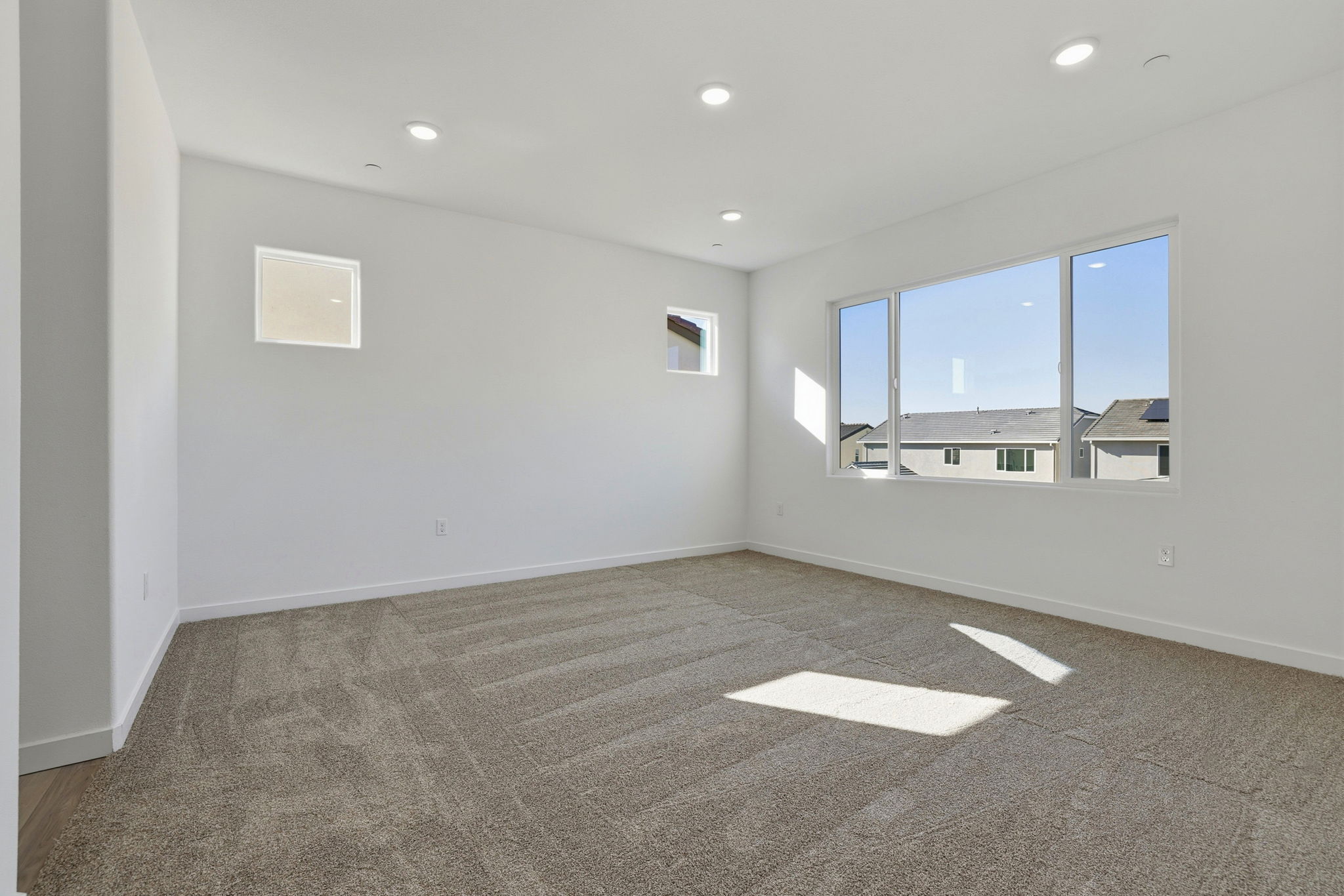 A room with a carpet and windows.