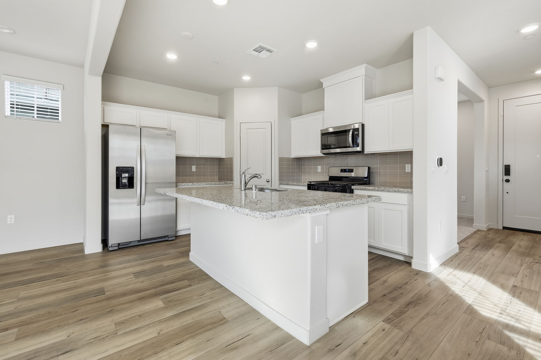 A kitchen with white cabinets.