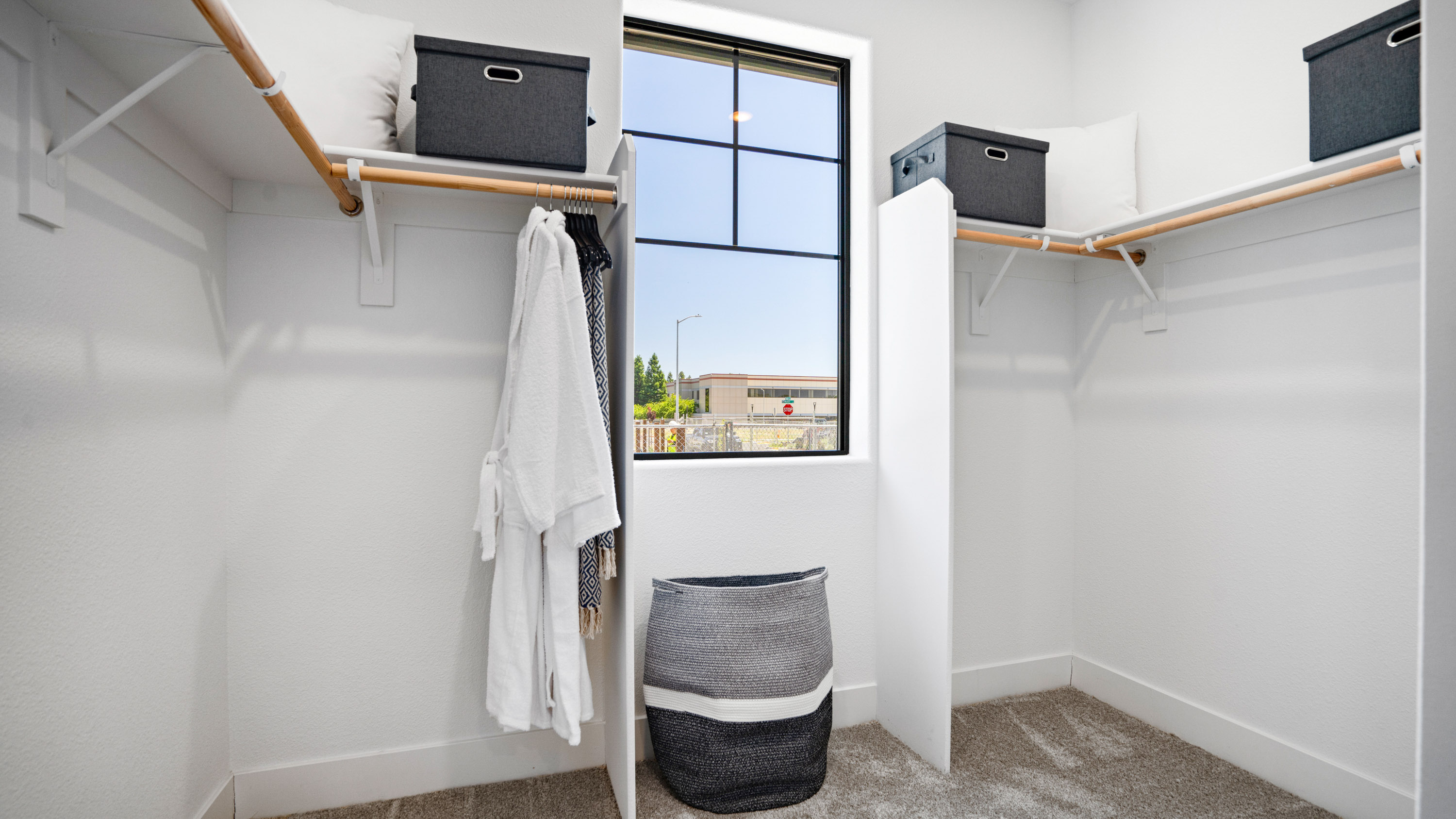 A room with a bed and a shelf with a laptop on it.