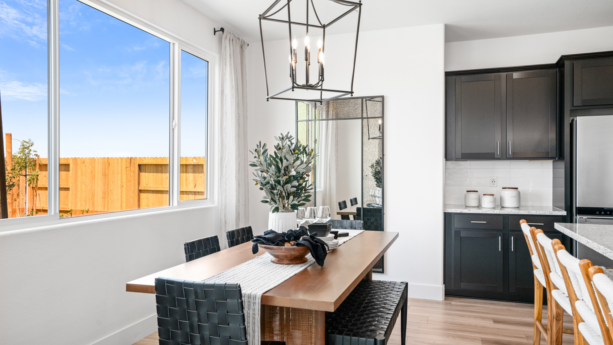 A dining room with a chandelier and a table with chairs.