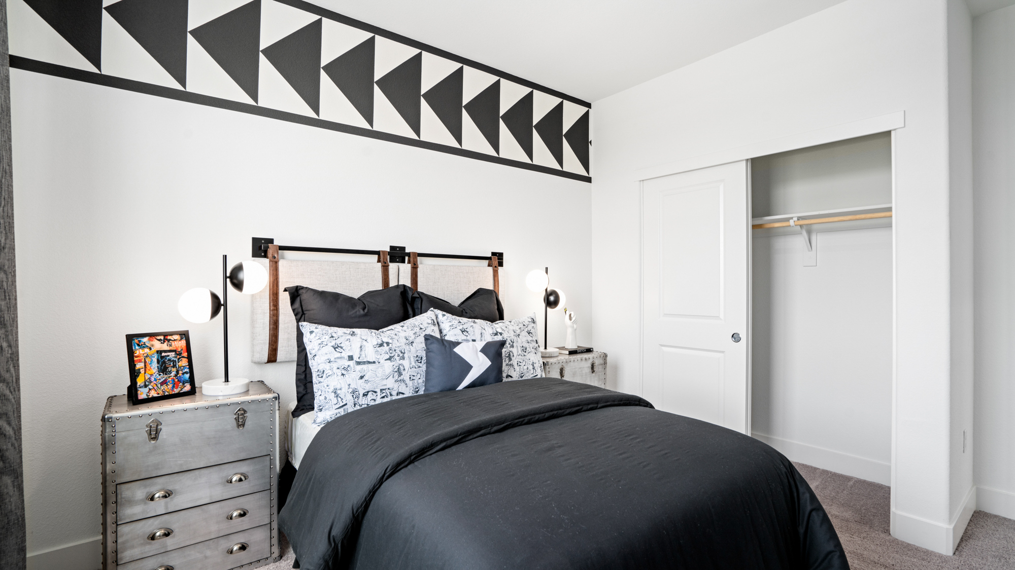 A bed with a black and white bed spread.