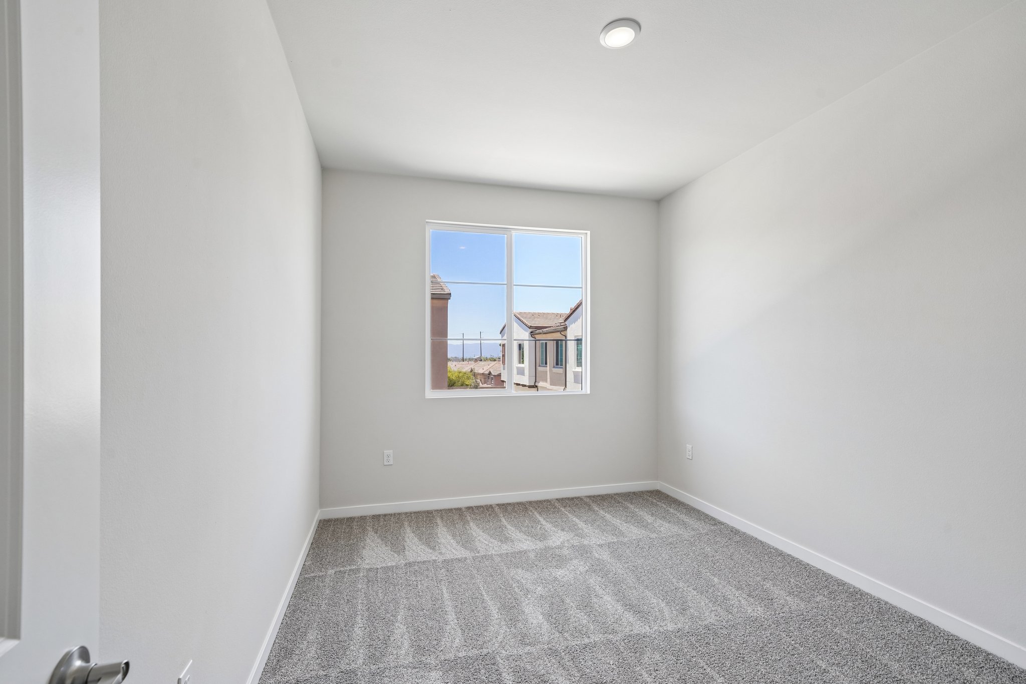 A room with a window and carpet.