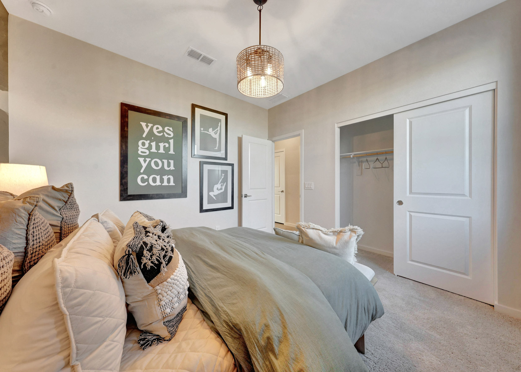 A bedroom with a bed and a chandelier.