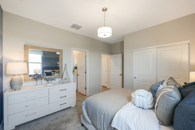 A bedroom with a bed and a mirror.