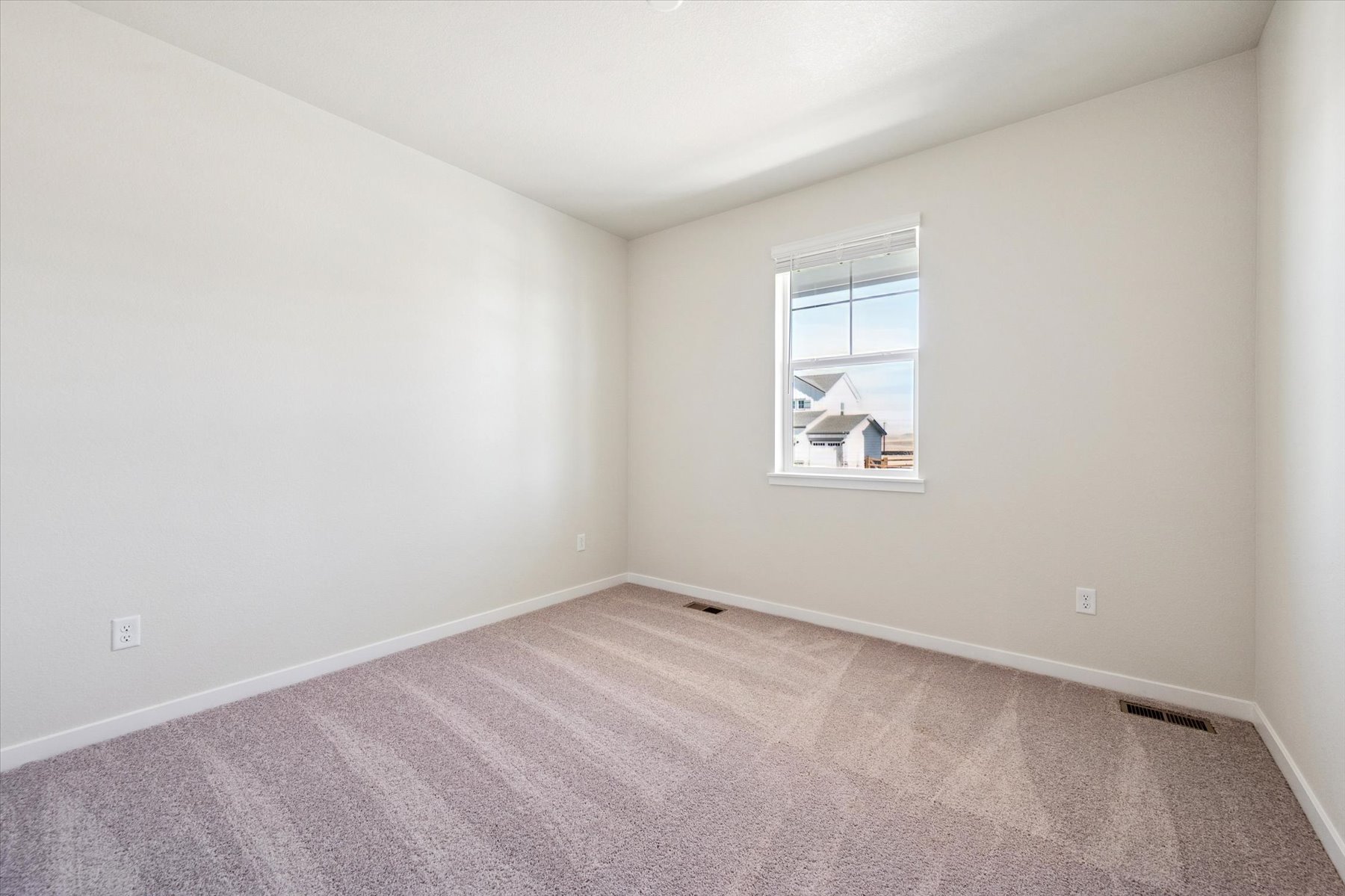 A room with a window and carpet.