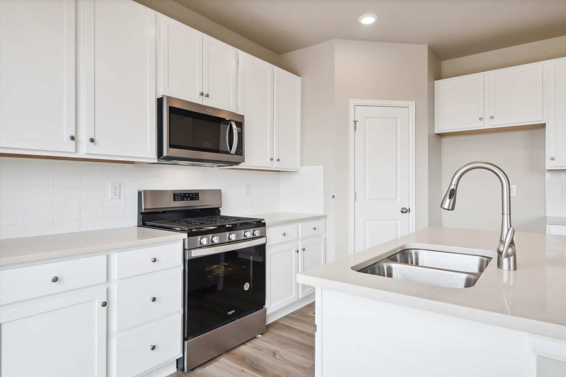 A kitchen with white cabinets.