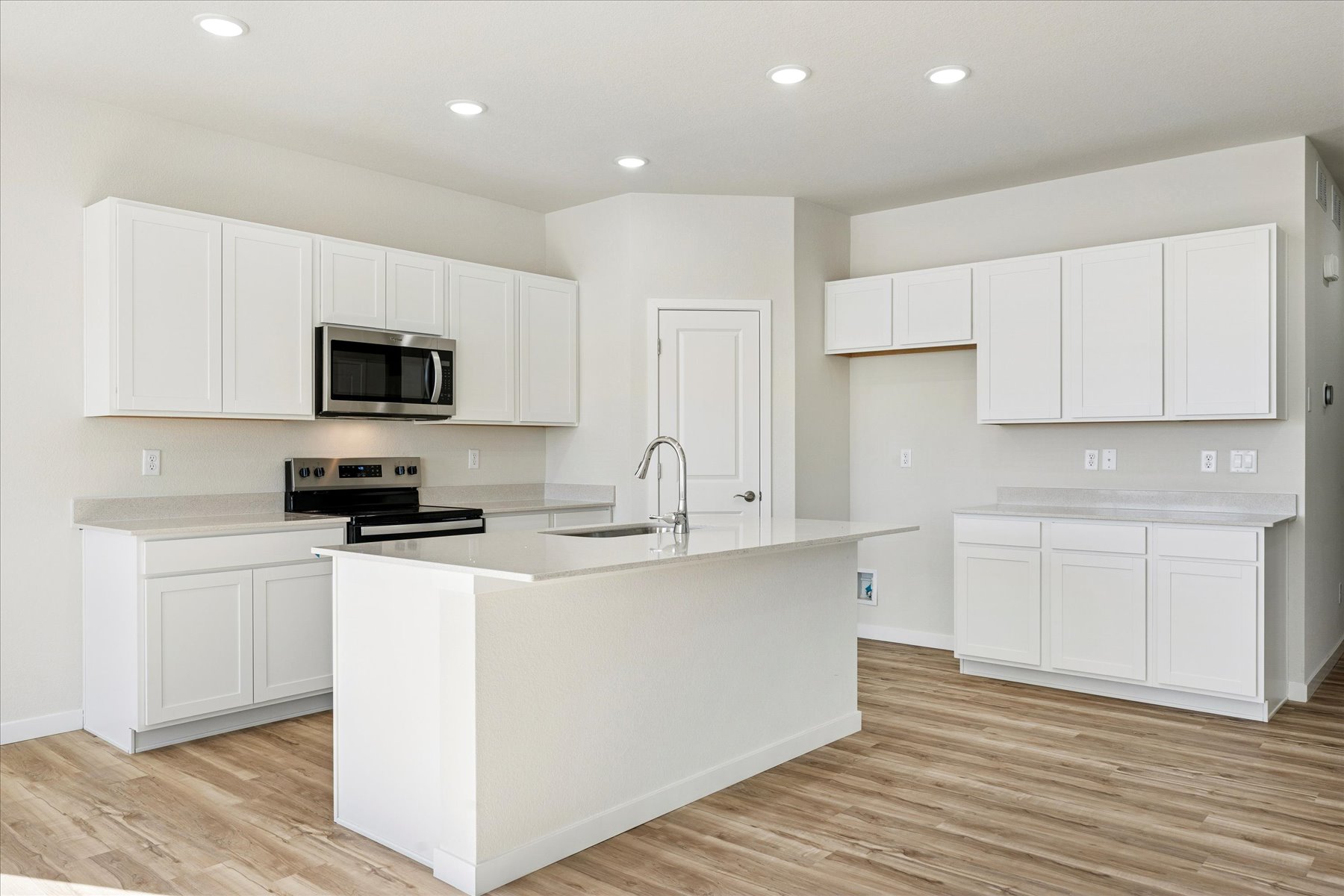 A kitchen with white cabinets.