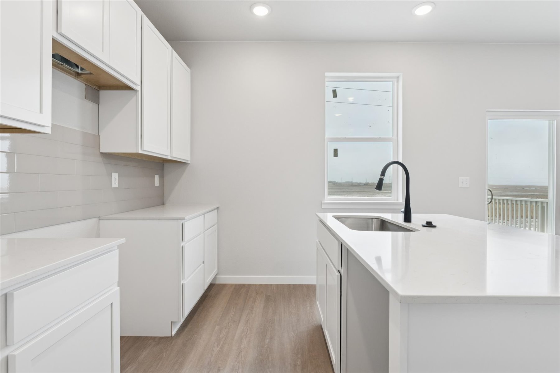 A kitchen with white cabinets.