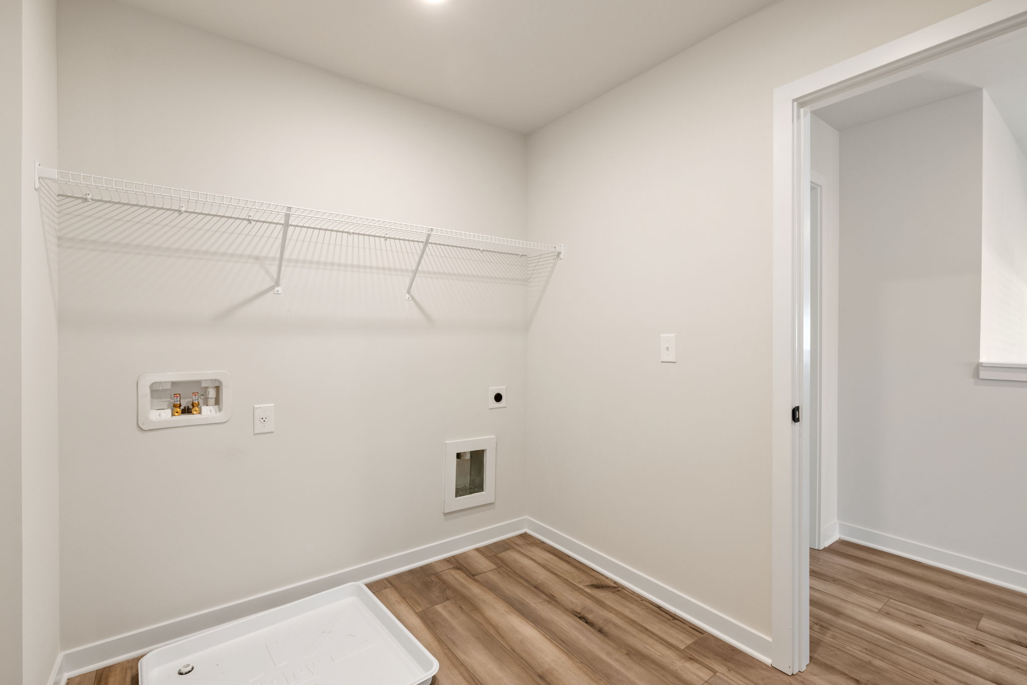 A room with a wood floor and white walls.