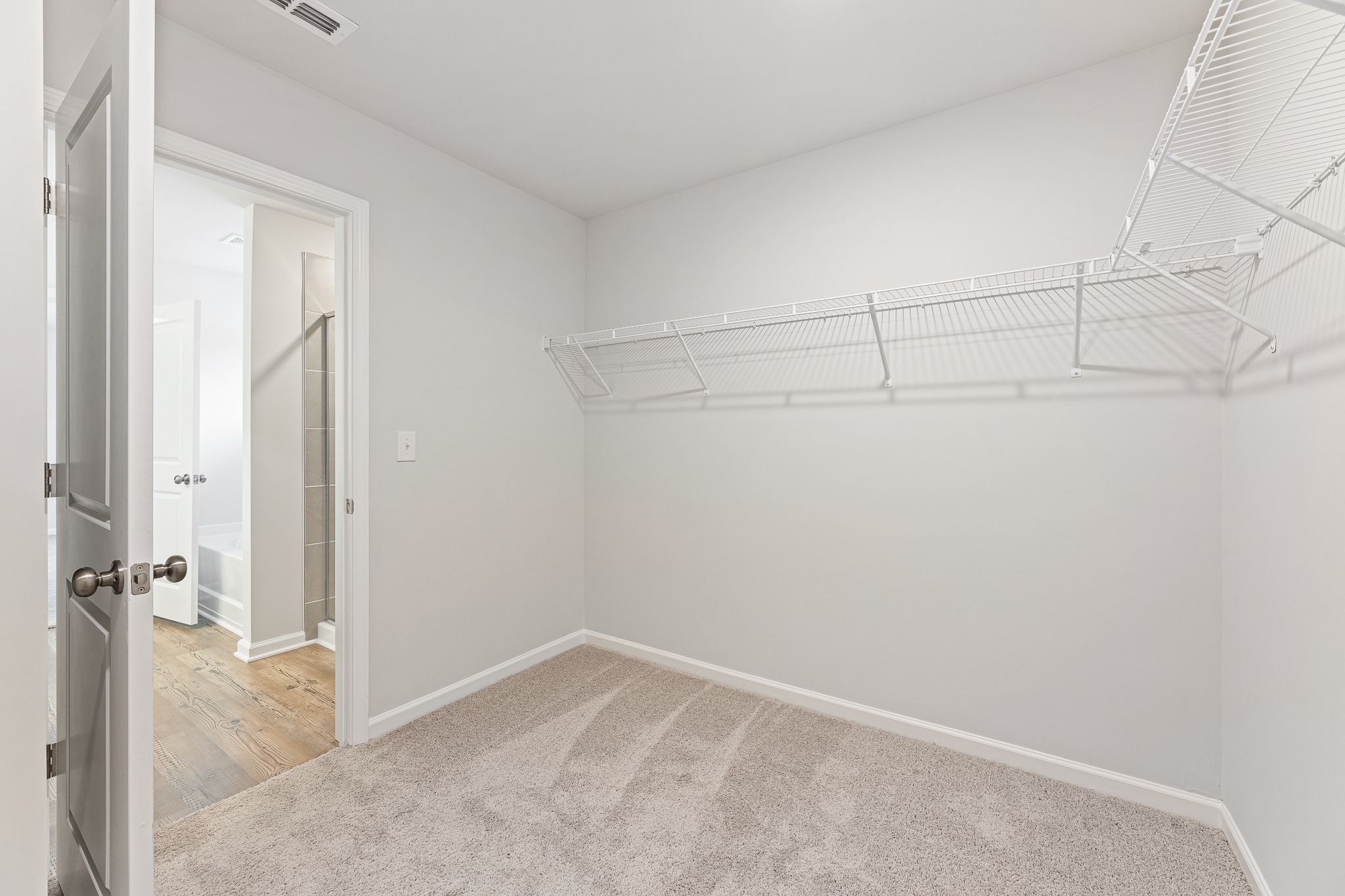 A room with a white wall and a metal railing.