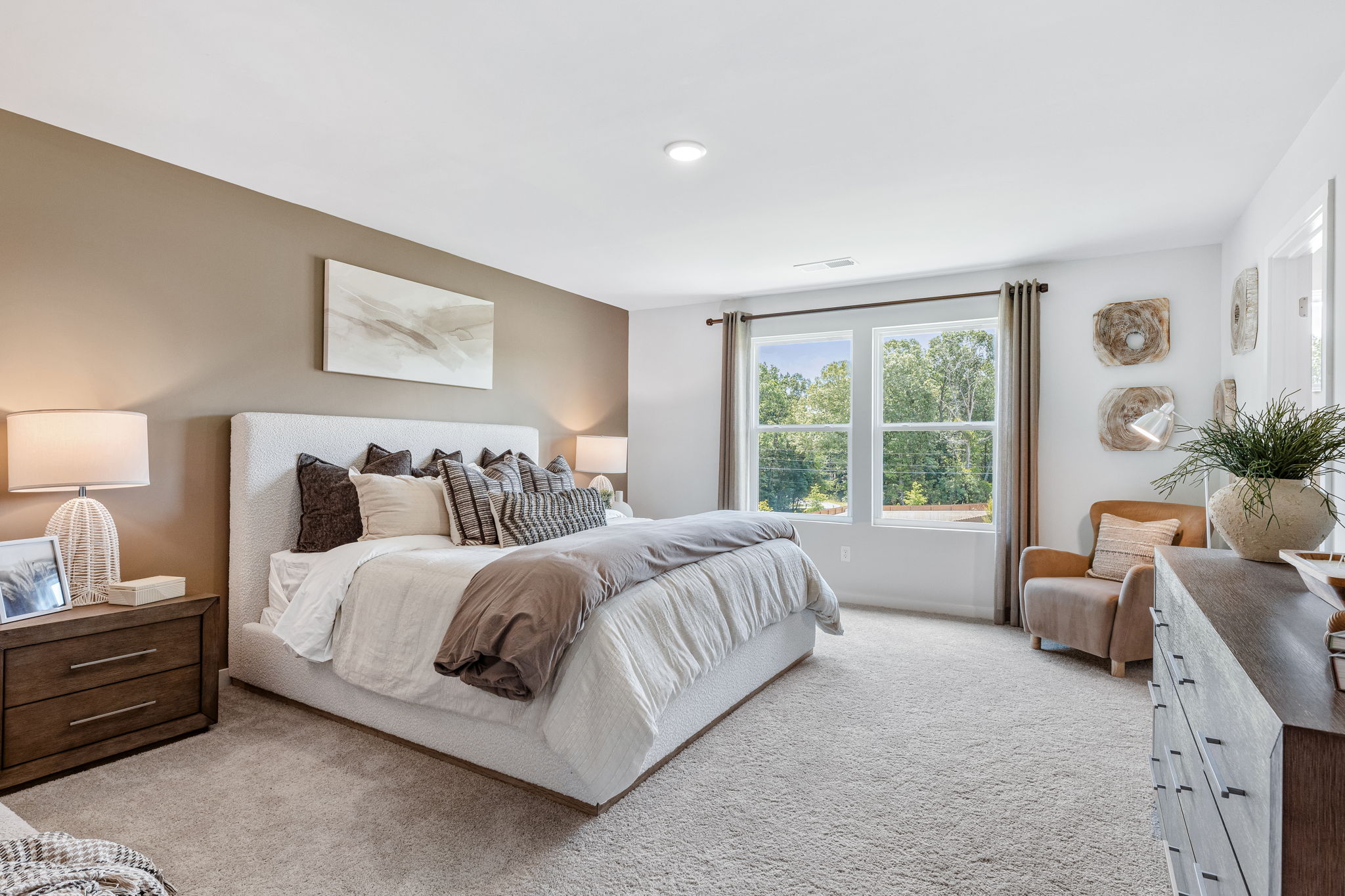 A bedroom with a bed and a chair.