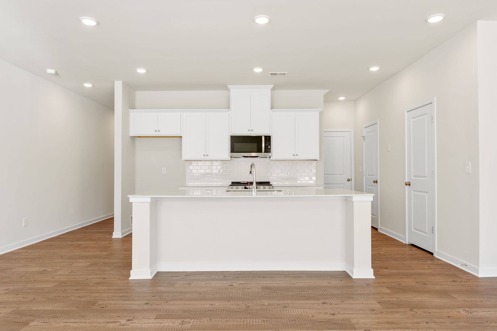 A kitchen with white cabinets.
