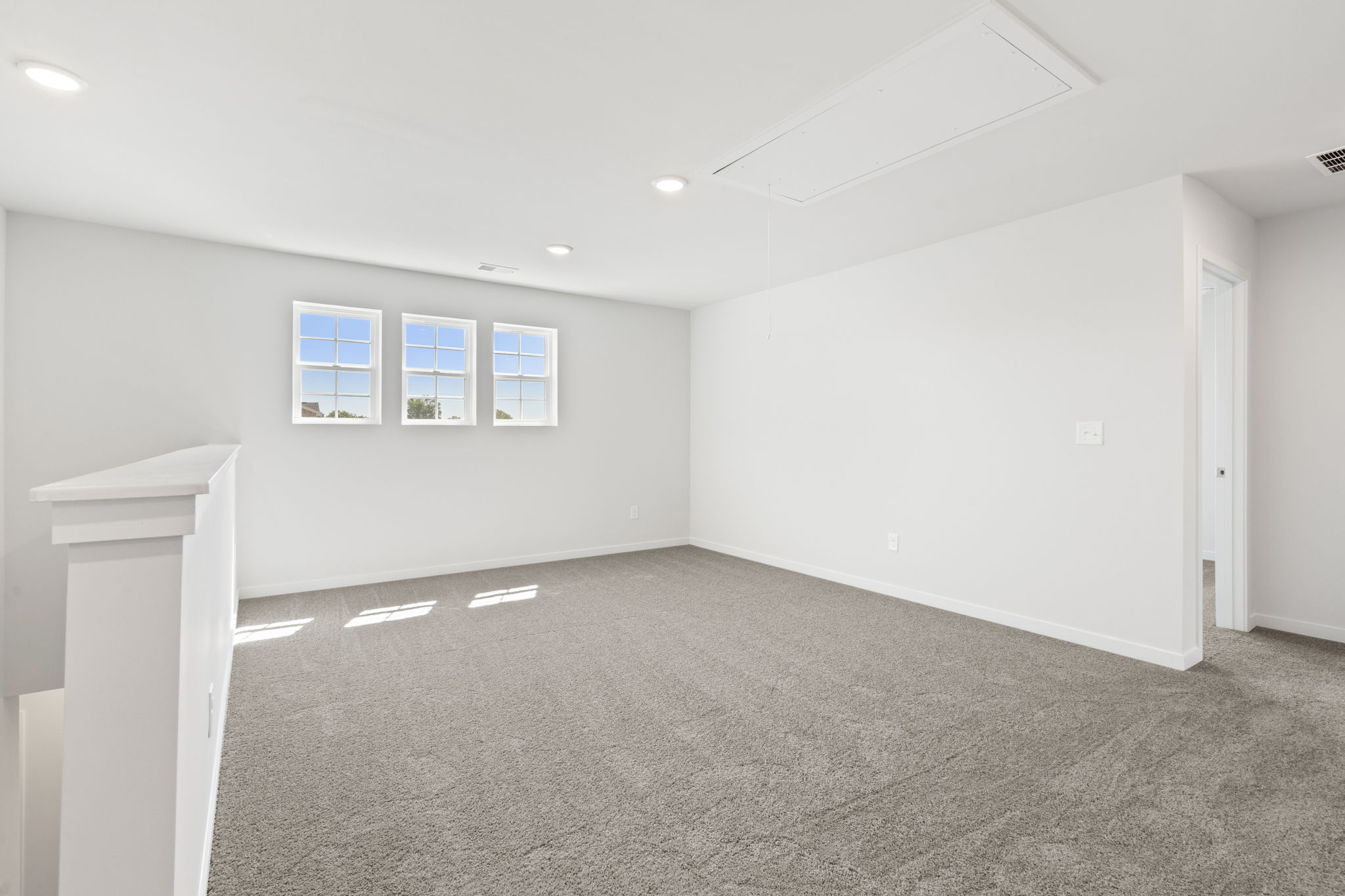 A room with a white wall and a window.