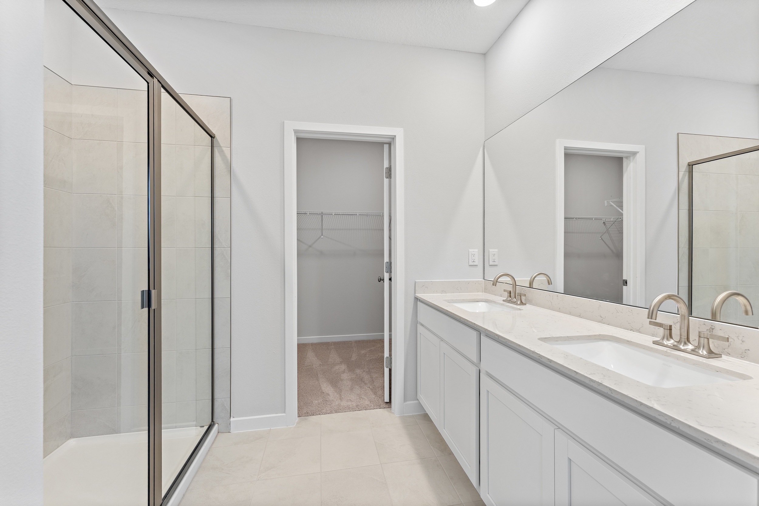 Lot 20 Ponderosa II Primary Bathroom with Double Vanity Sink and Glass Shower at Camden Woods in Kingsland, GA