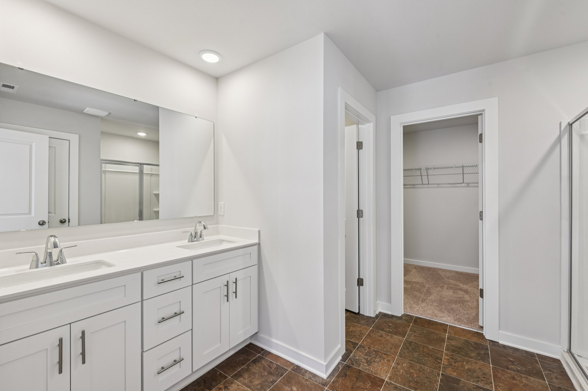 A bathroom with white cabinets.