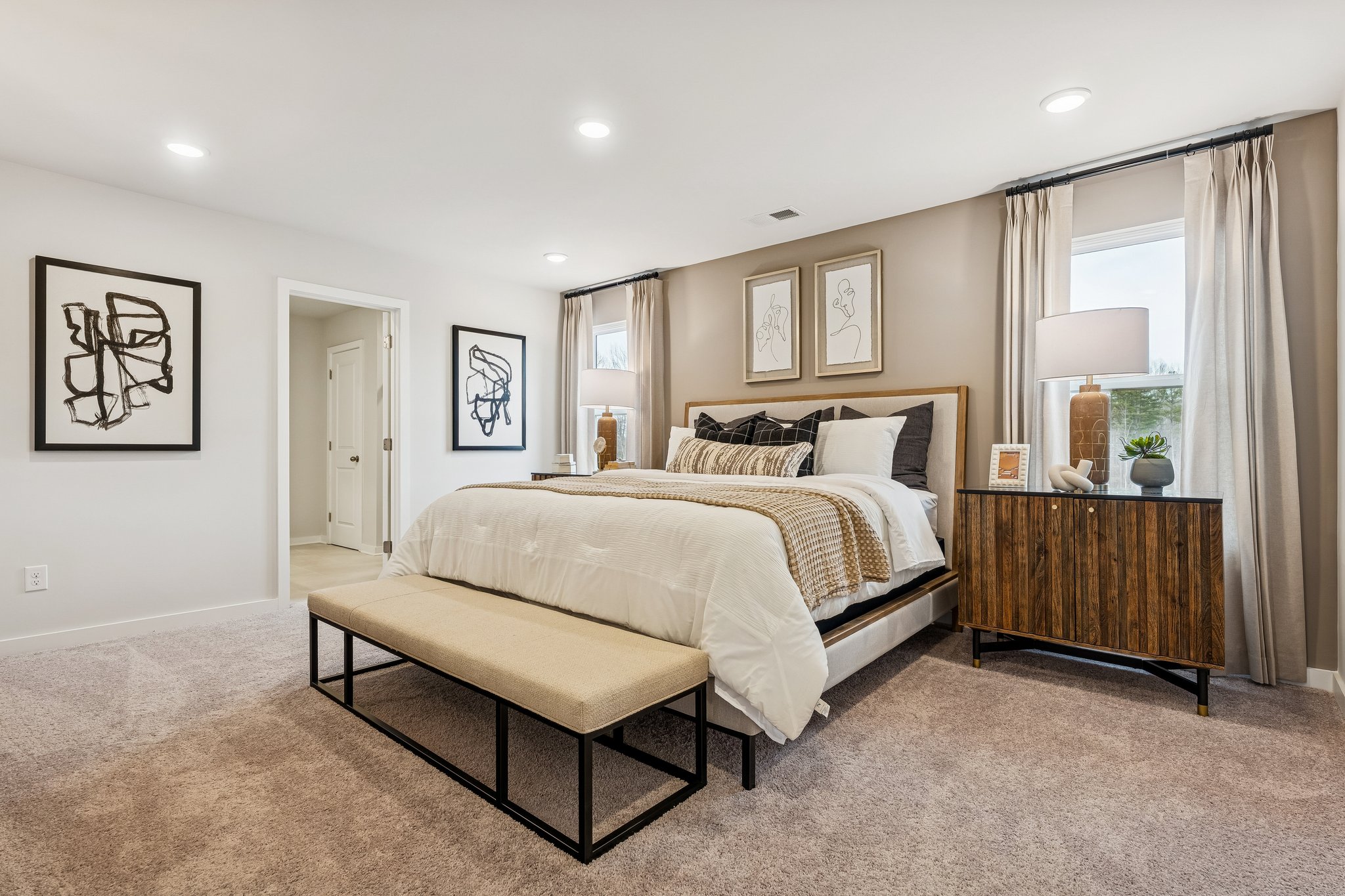 A bedroom with a bed and a bench.