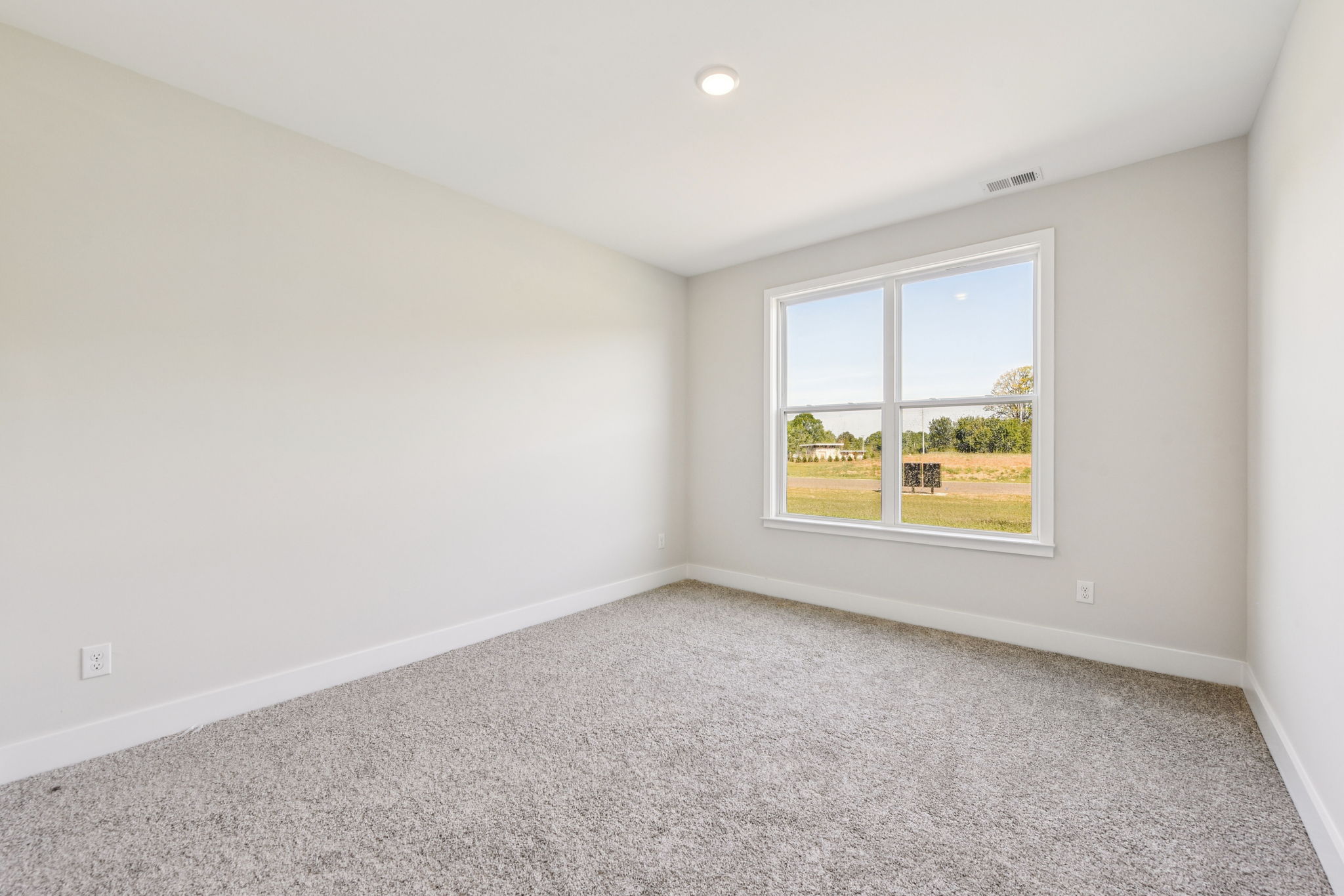 A room with a window and a carpet.
