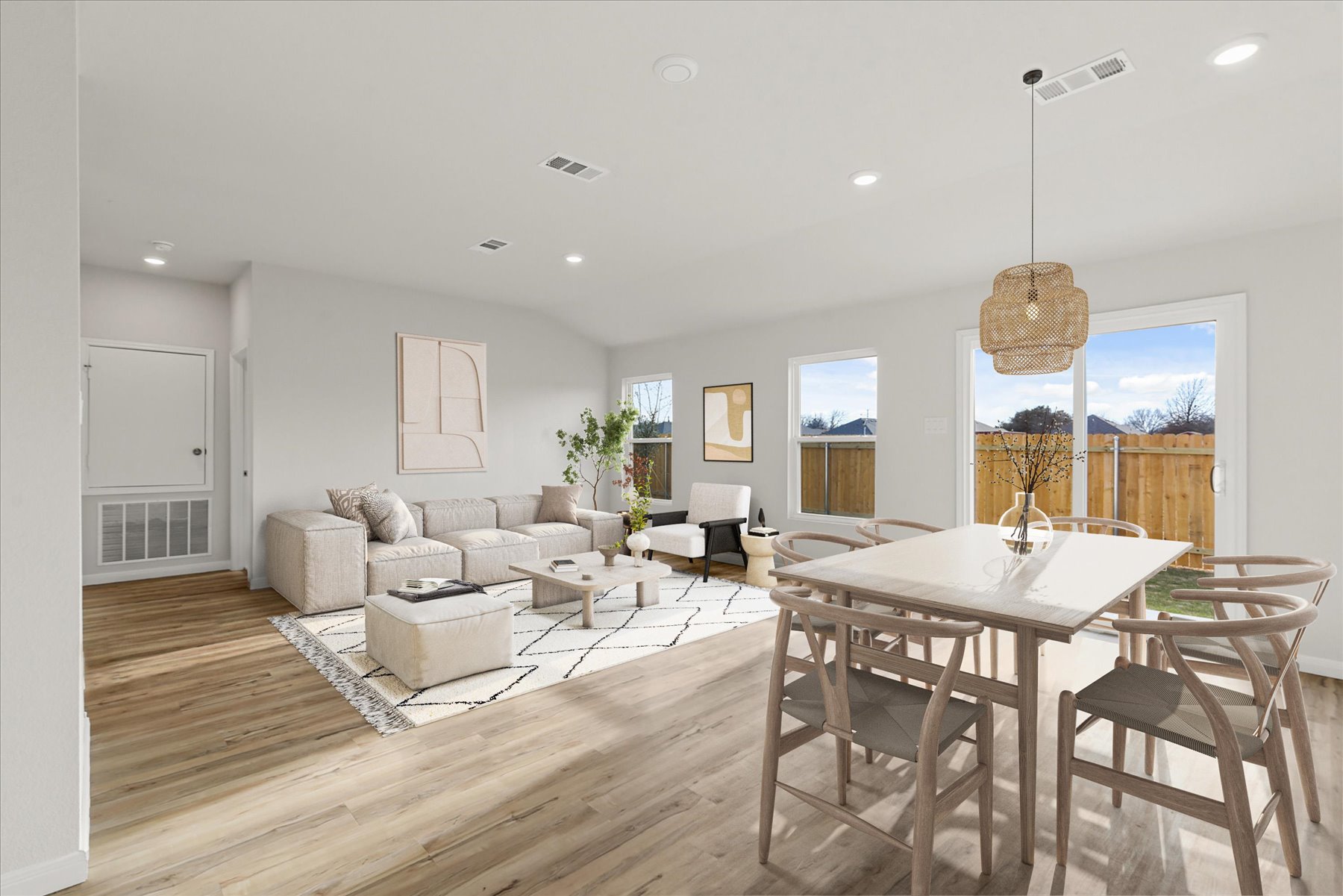 A large living room with a large dining table and a large window.