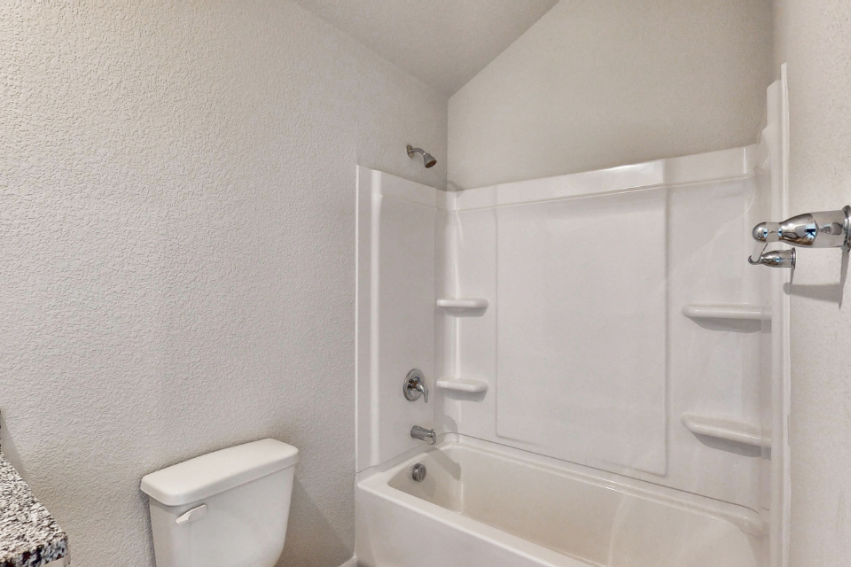 A bathroom with a tub toilet and sink.
