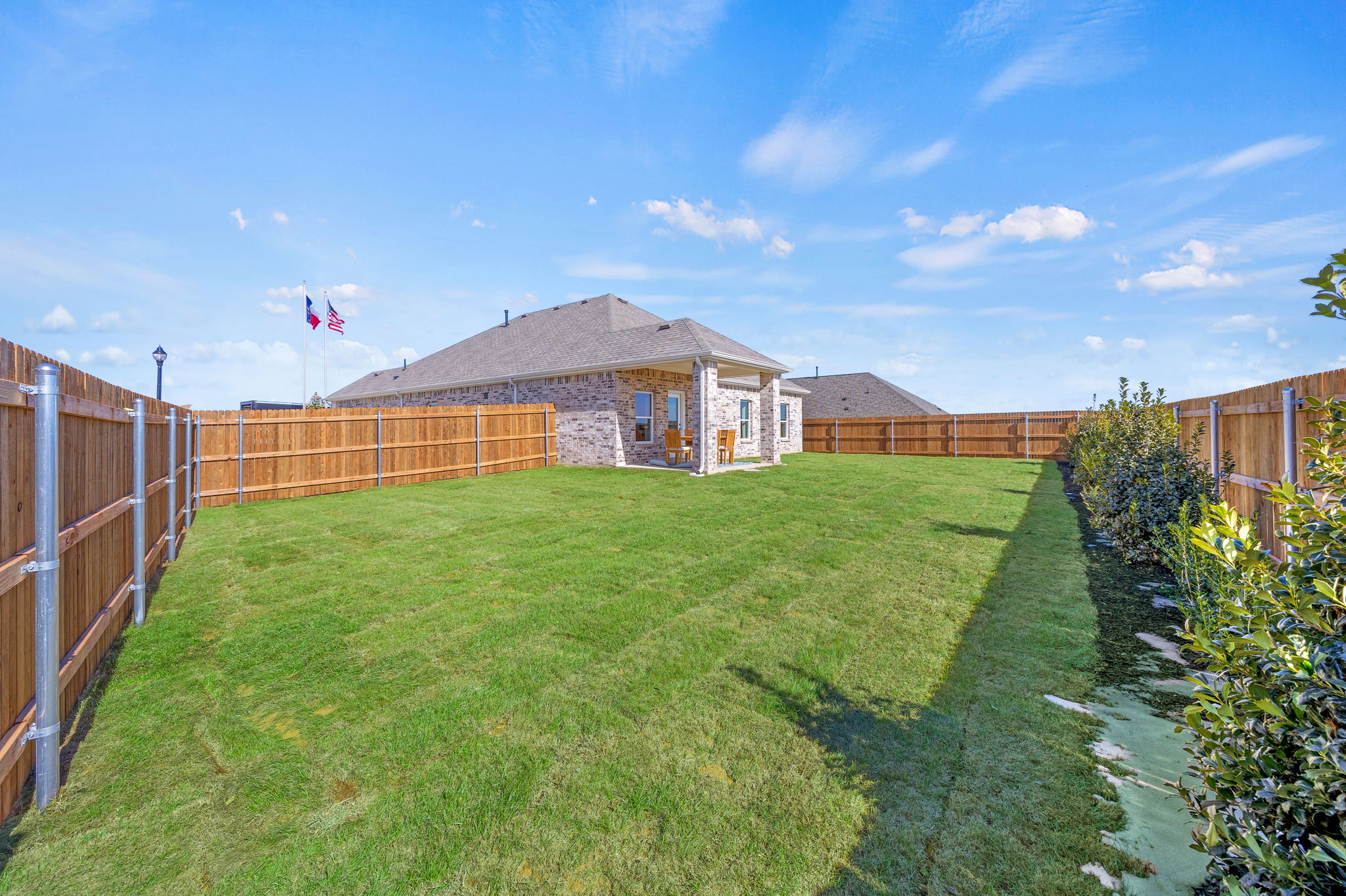 A fenced in yard with a building in the background.