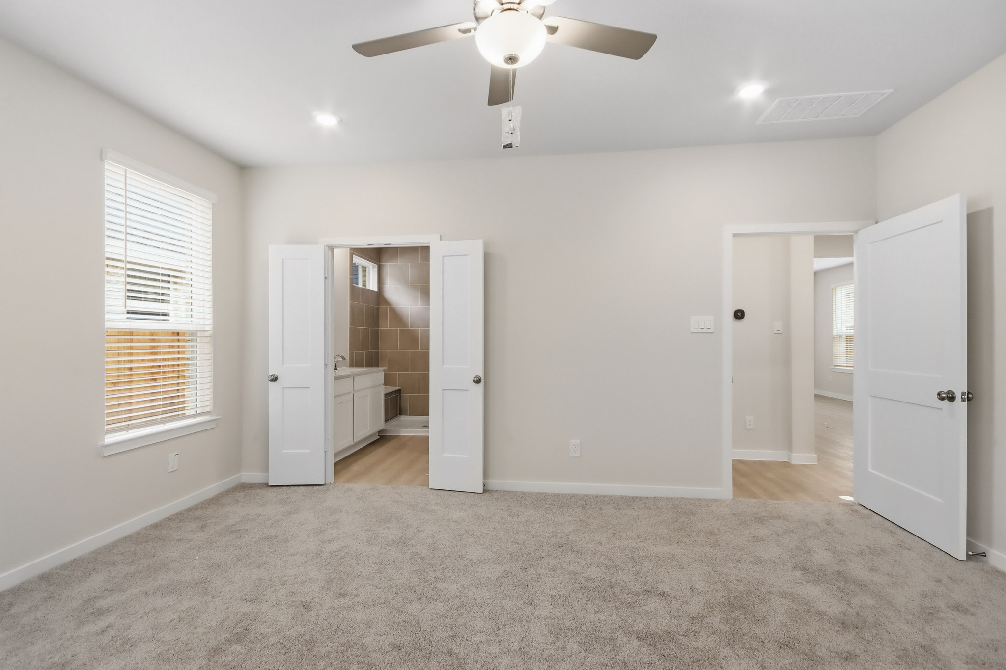 A room with white cabinets and a fan.