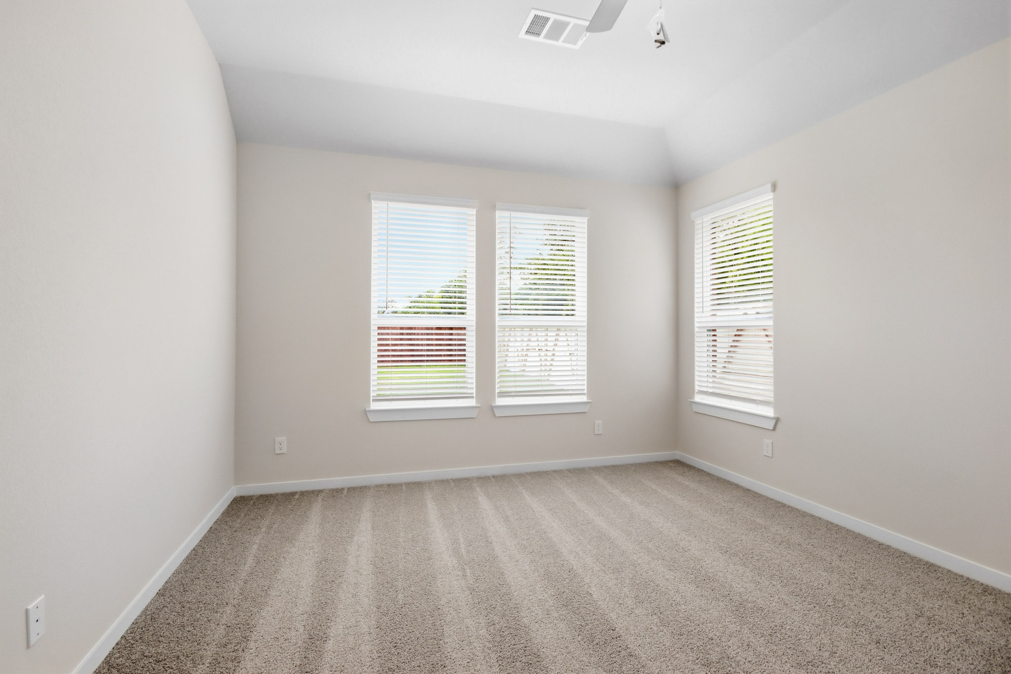 A room with a carpet and windows.