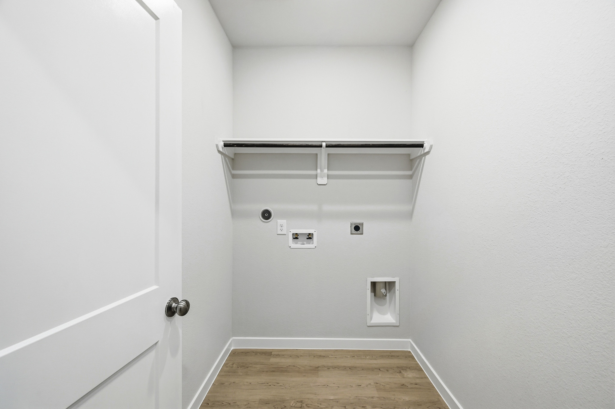 A white room with a wood floor.