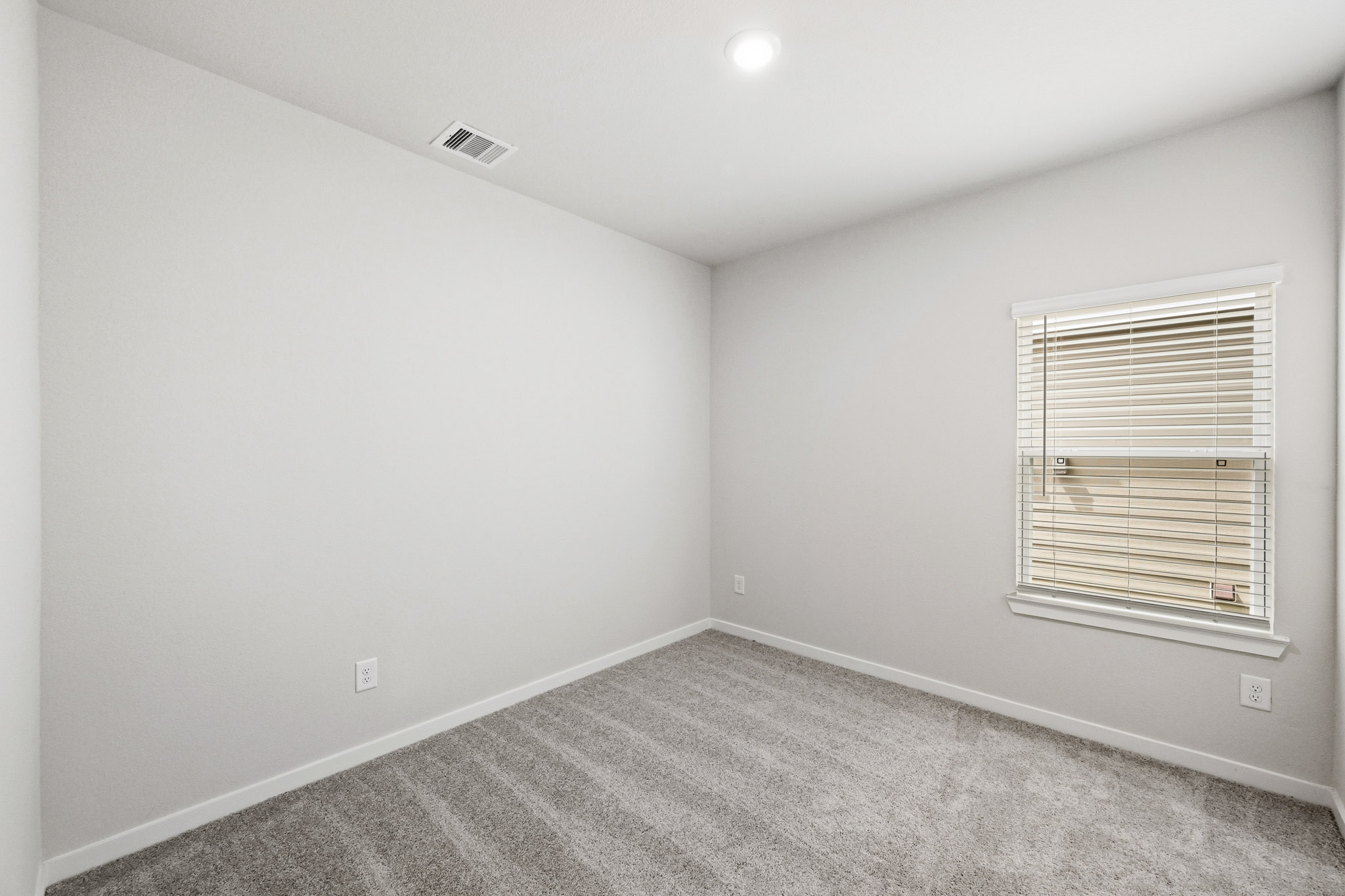 A room with a window and a carpet.