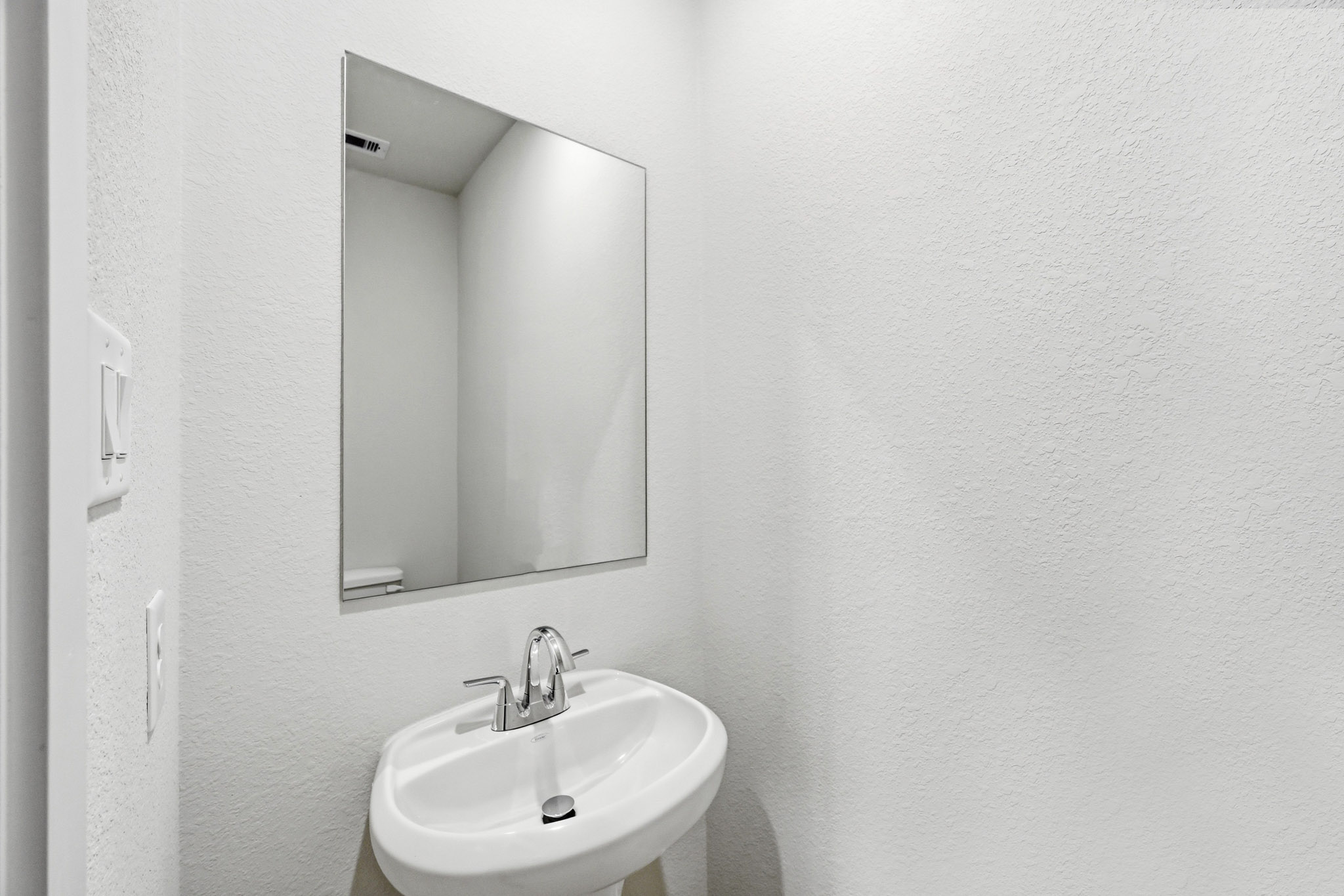 A bathroom with a round mirror.