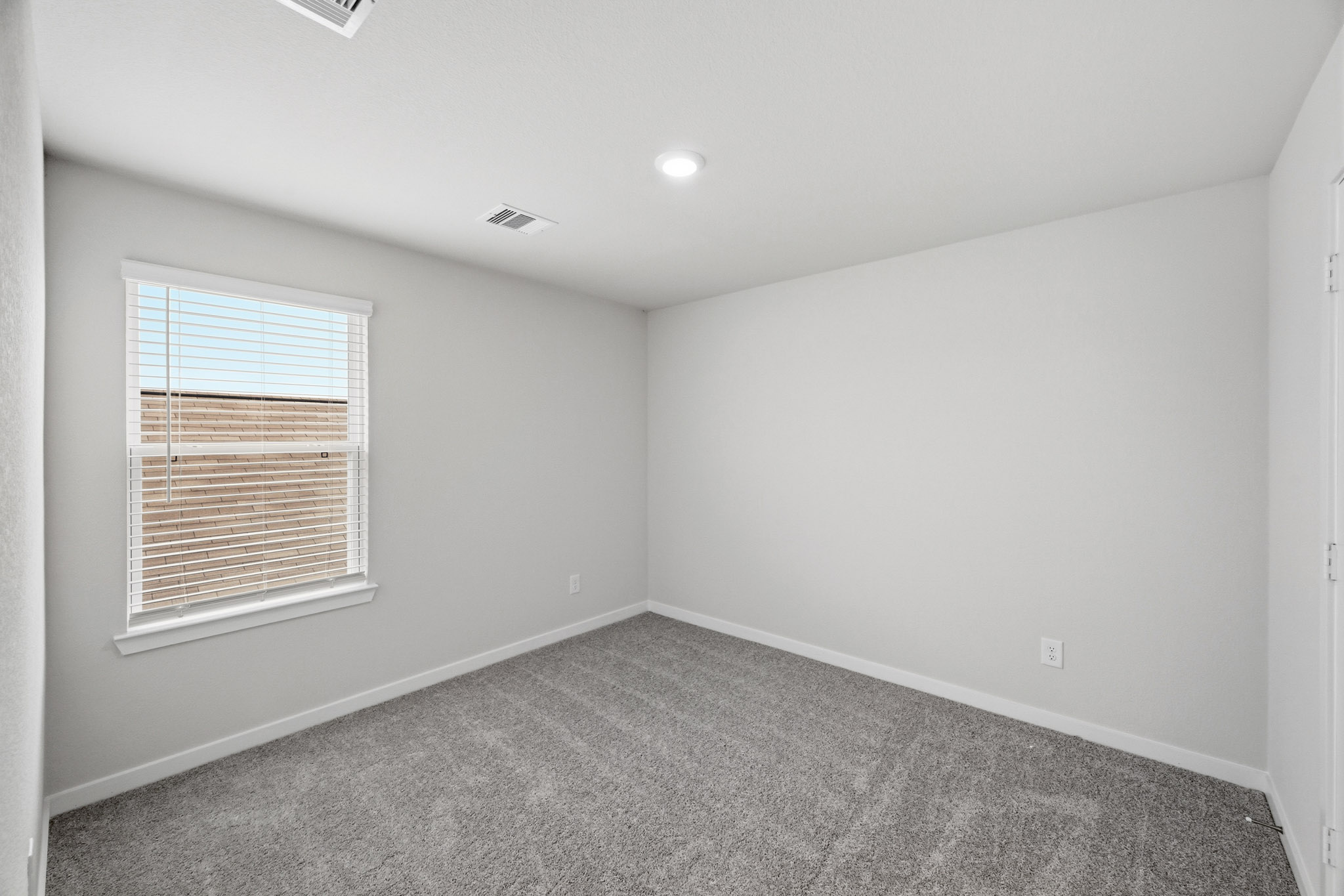 A room with a window and carpet.