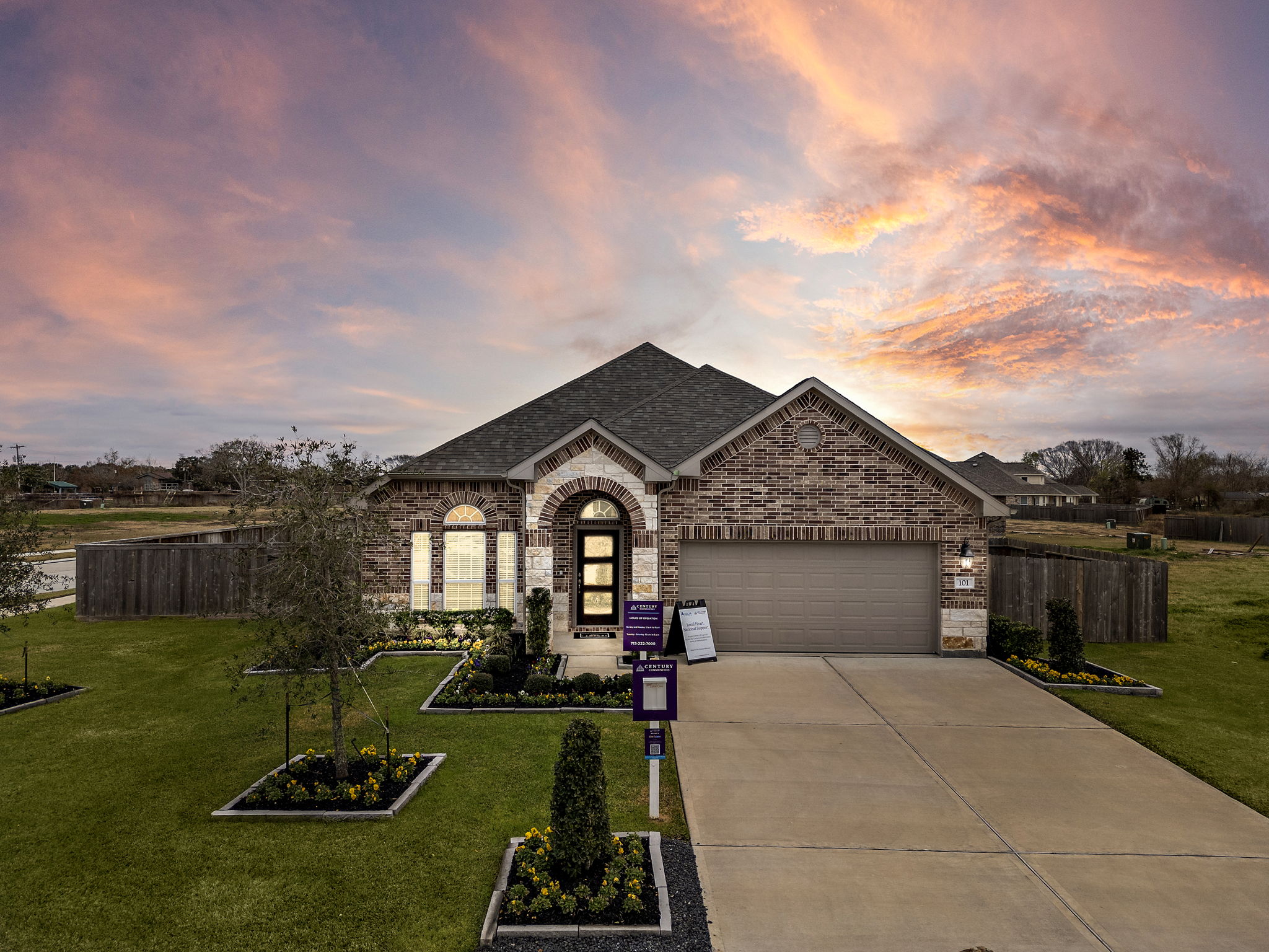A building with a driveway and a sunset in the background.