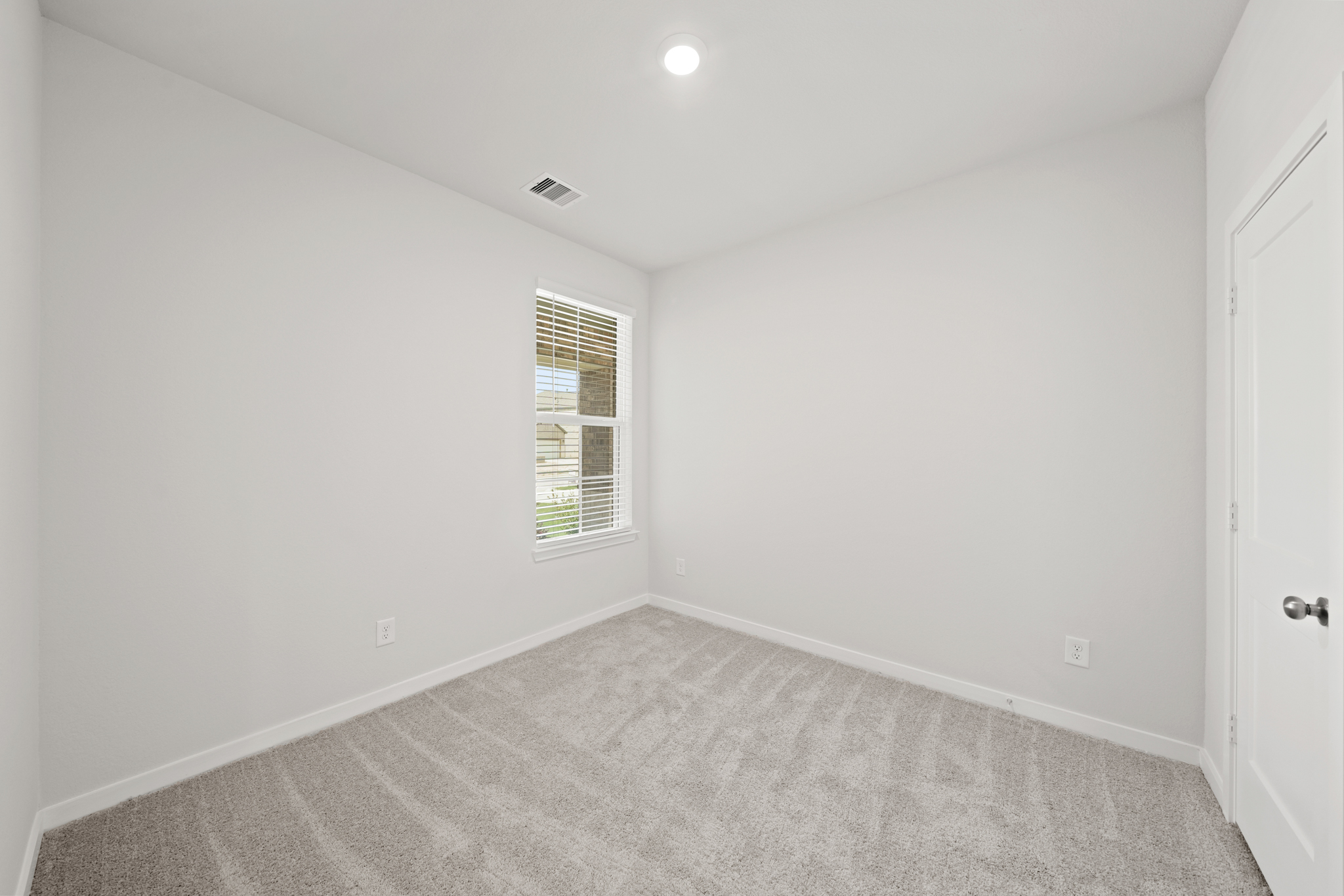 A room with a carpet and a window.