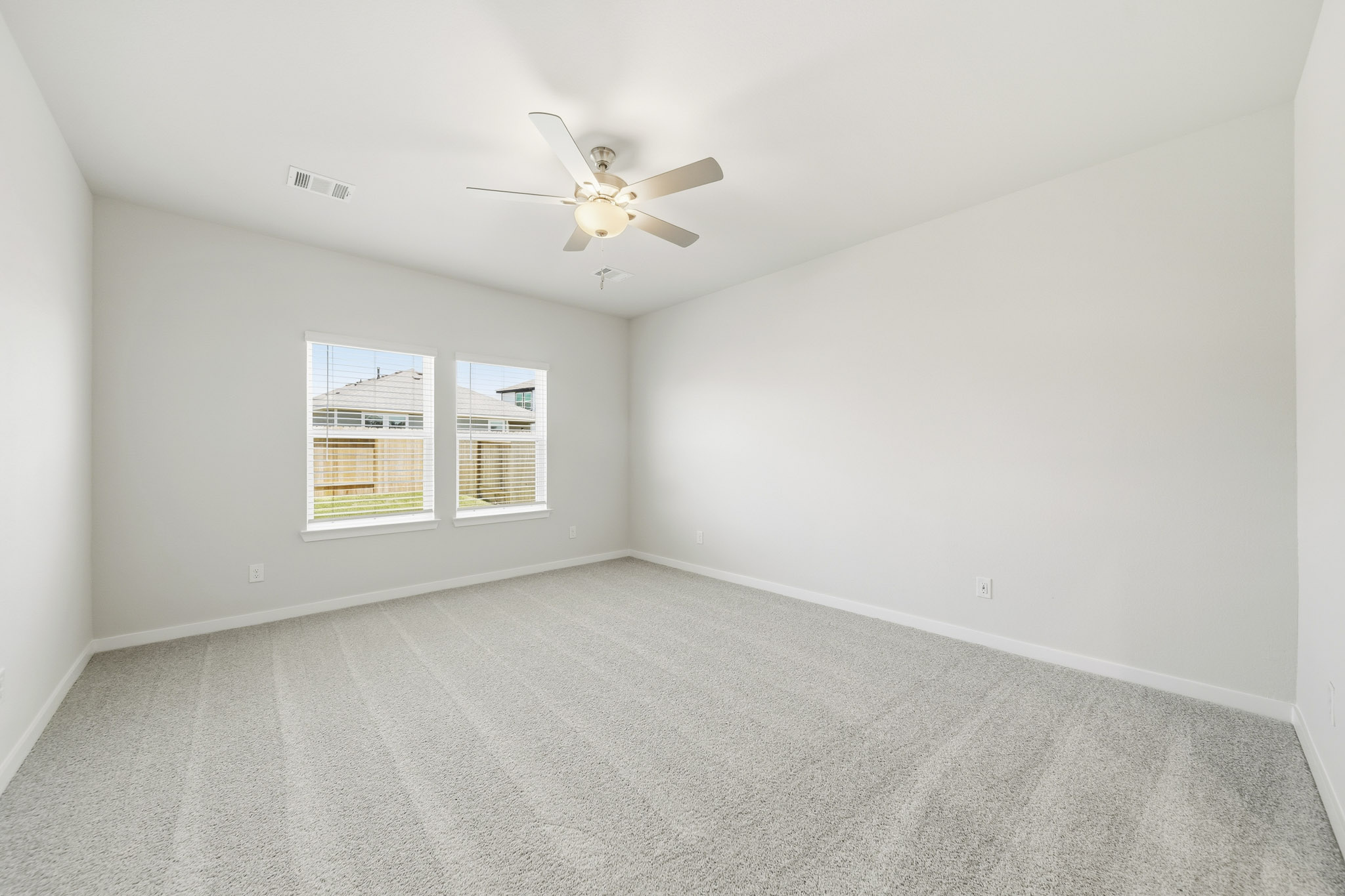 A room with a ceiling fan and a window.