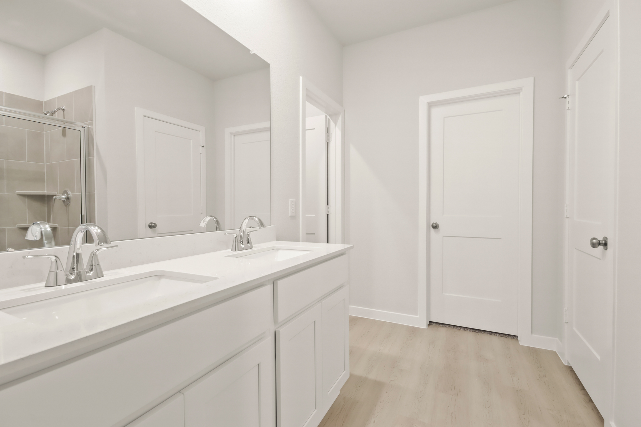 A bathroom with white cabinets.