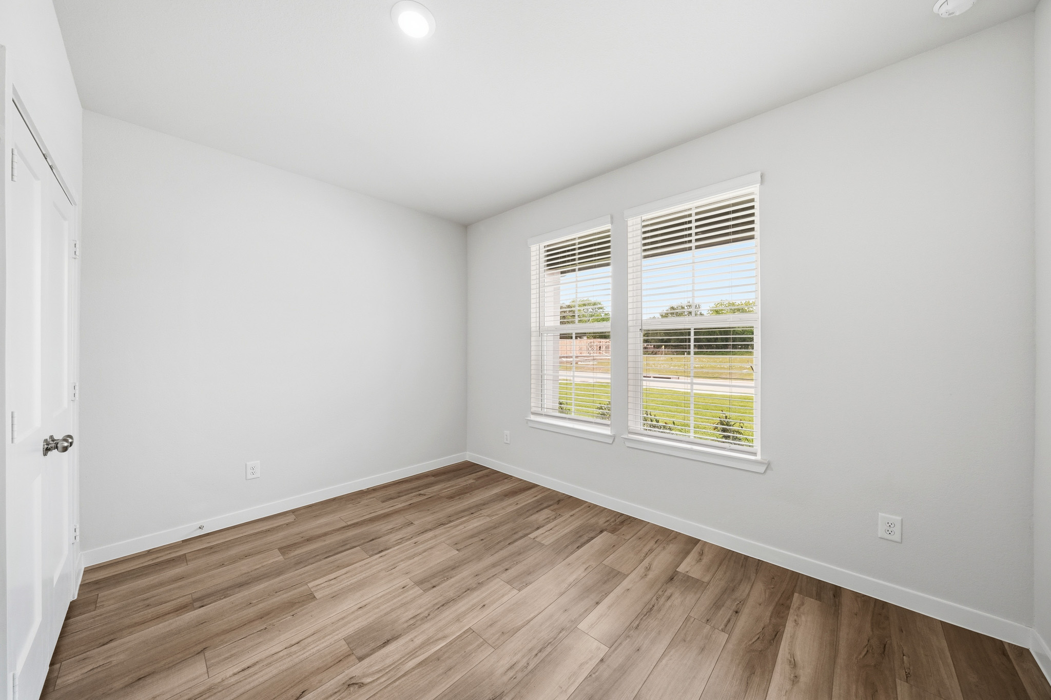 A room with a wood floor and windows.