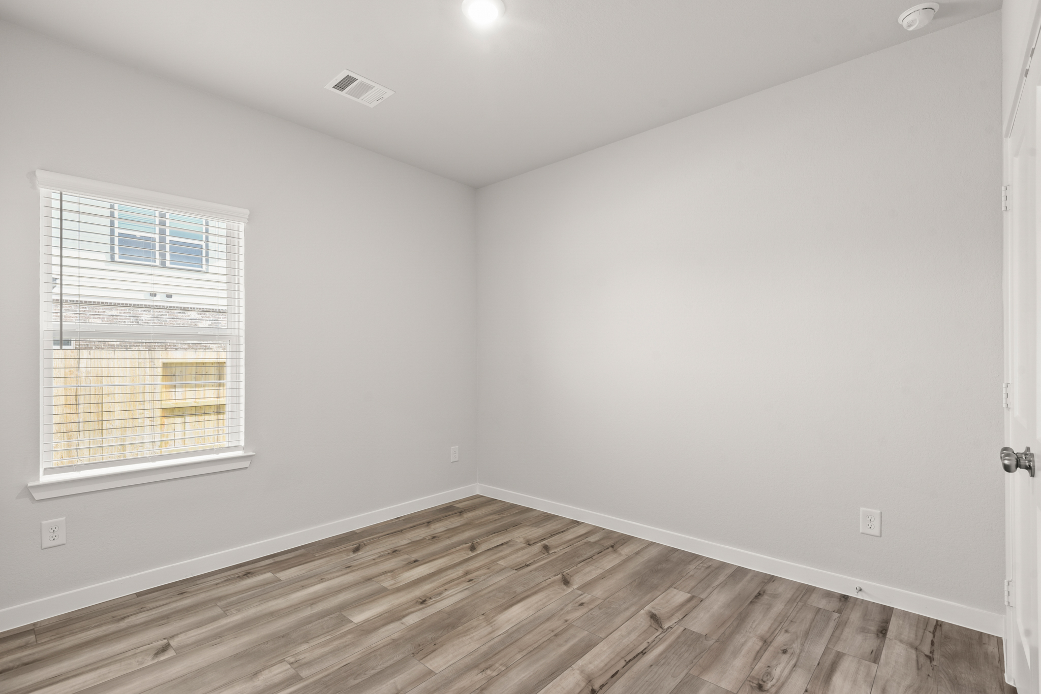 A room with a wood floor and a window.