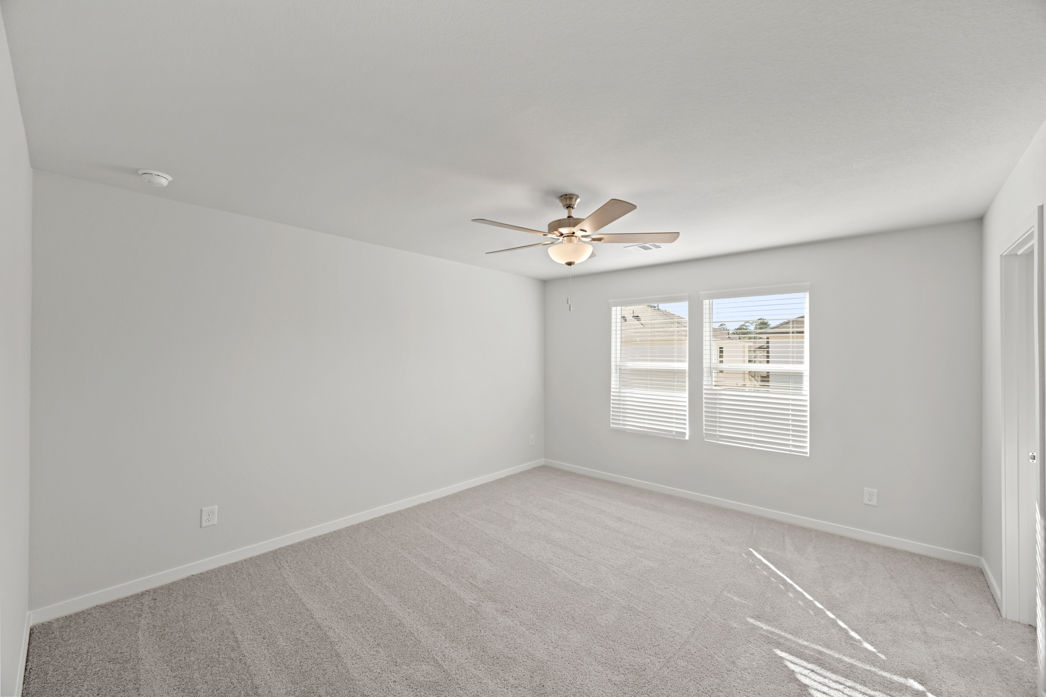 A room with a ceiling fan and a window.