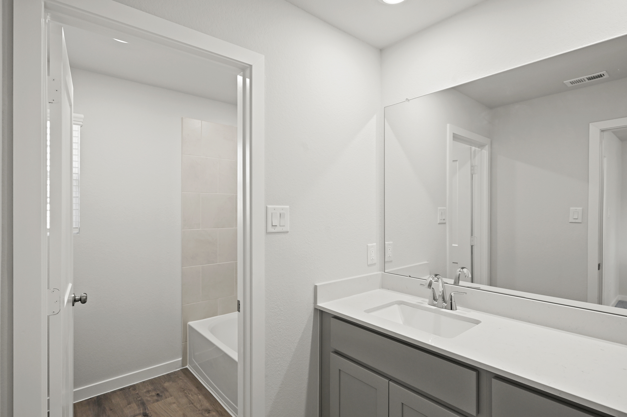 A bathroom with a tub sink and a shower.