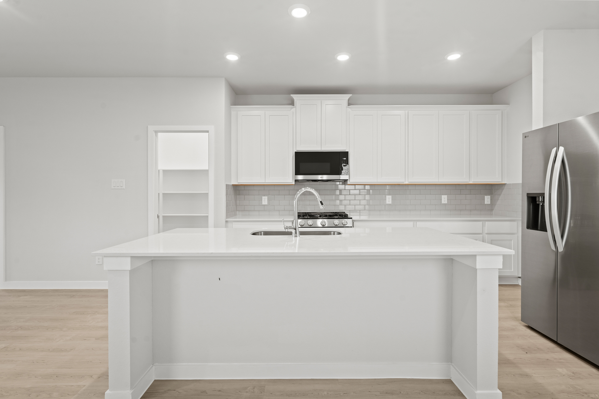 A kitchen with white cabinets.