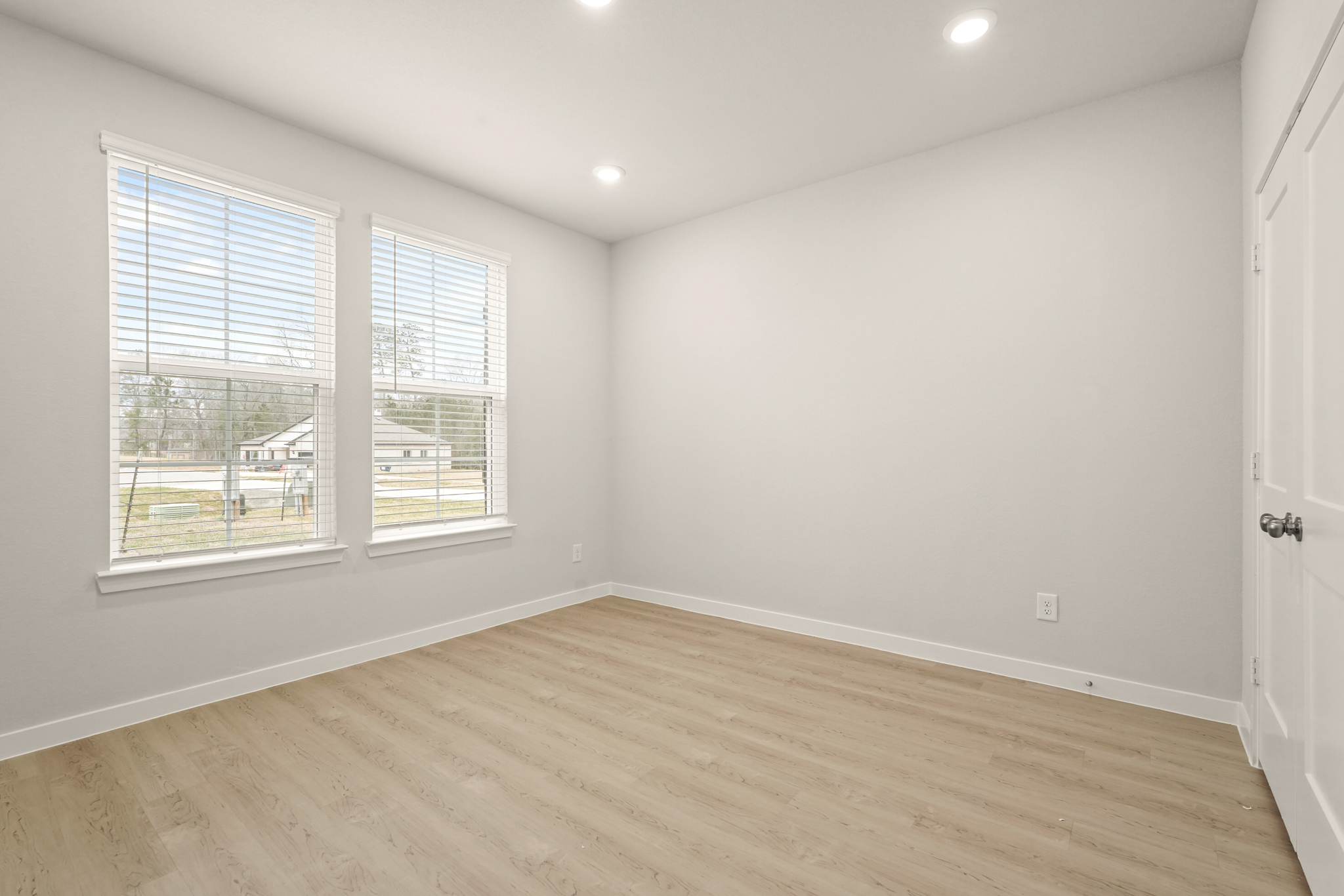 A room with a wood floor and windows.