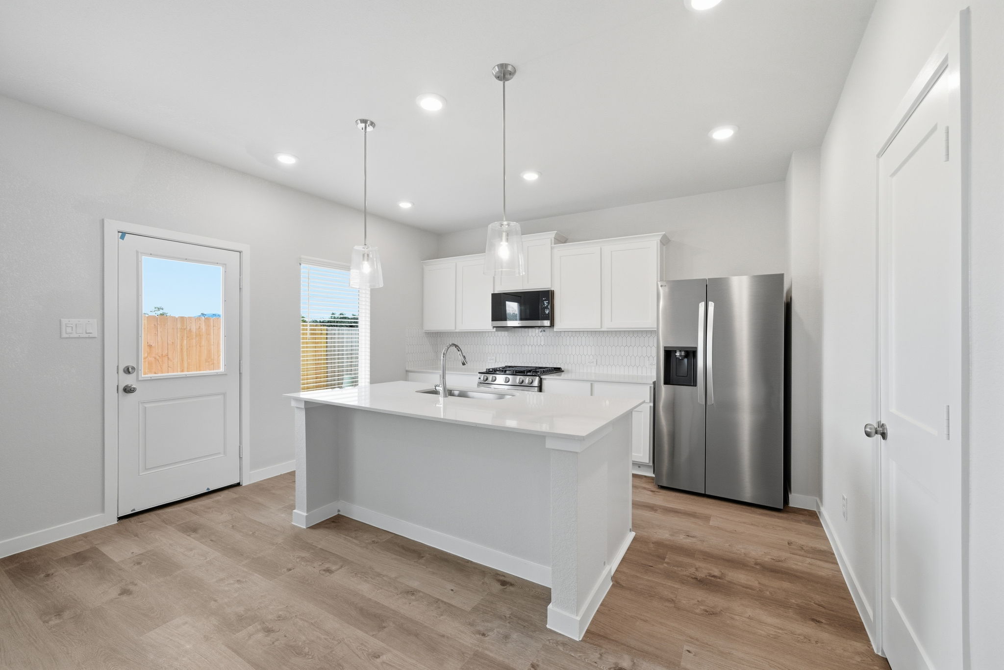 A kitchen with white cabinets.