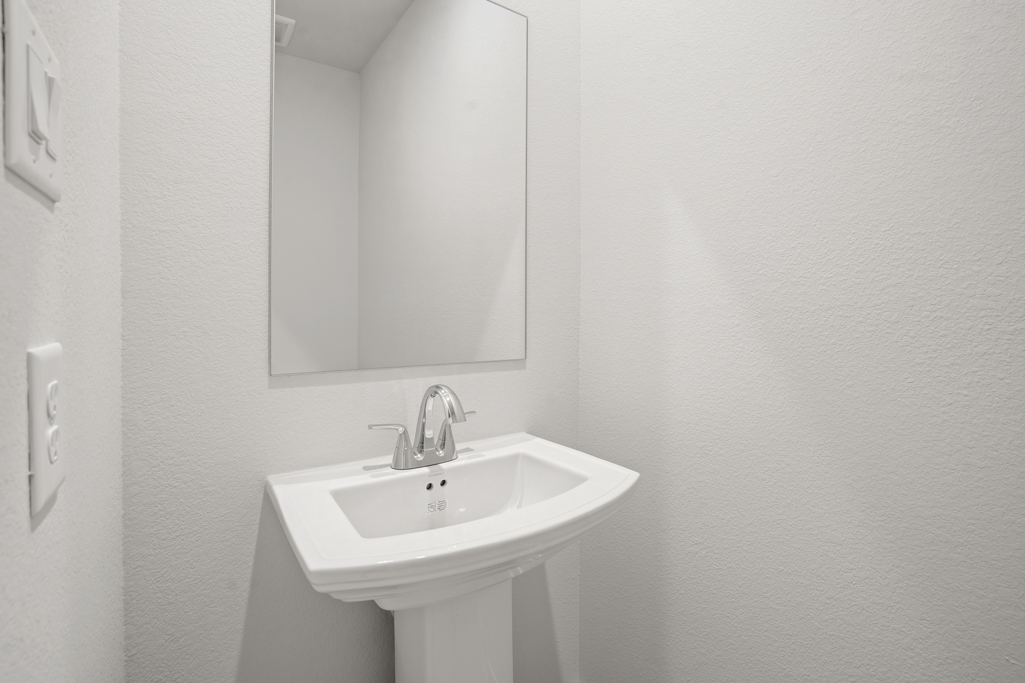 A bathroom with a mirror and sink.