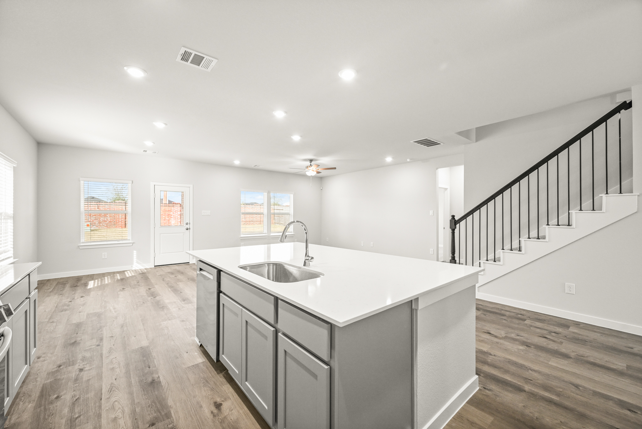 A kitchen with a large white countertop and a wood floor.