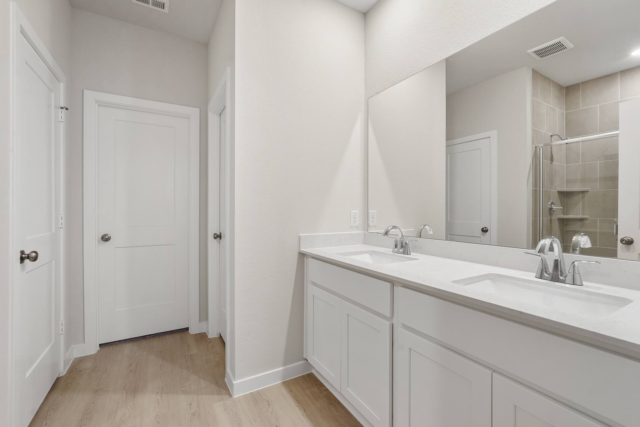 A bathroom with white cabinets.