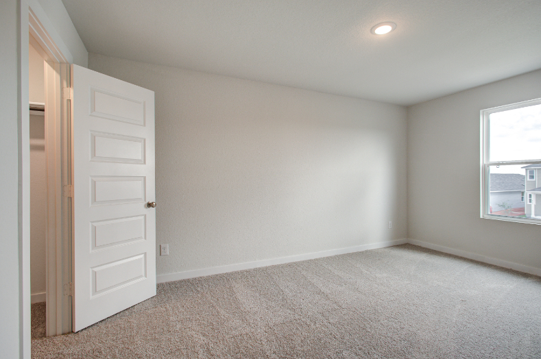 A room with a white door and a window.