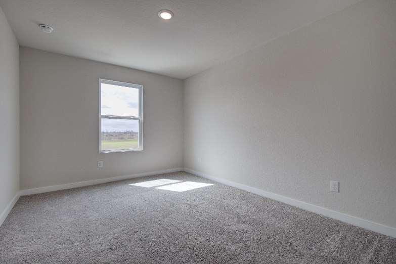 A room with a window and carpet.